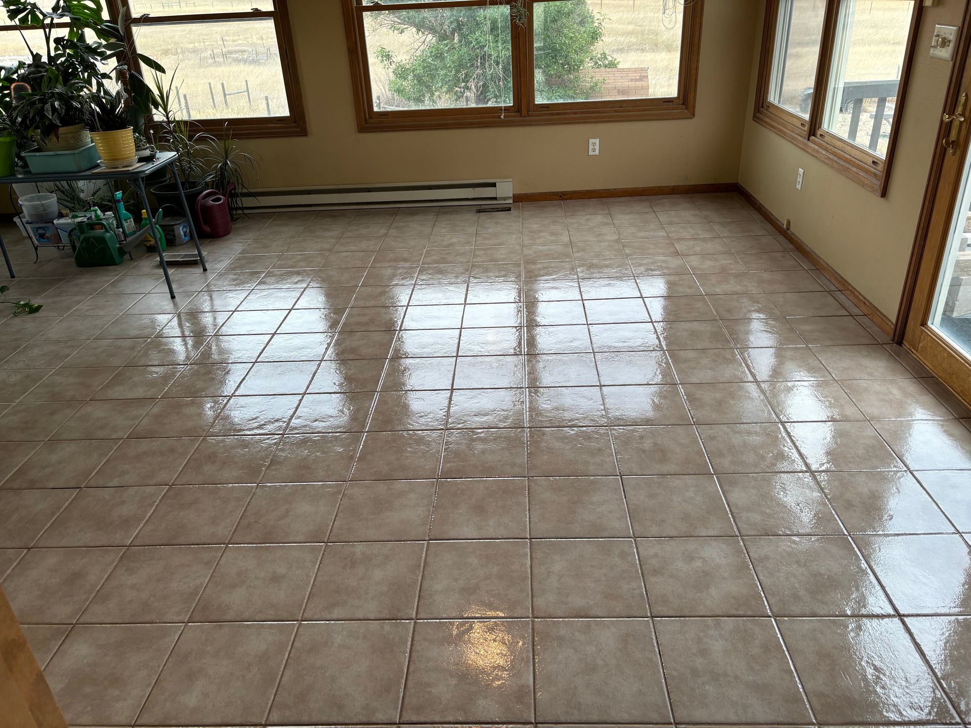 A tiled floor in a room with lots of windows
