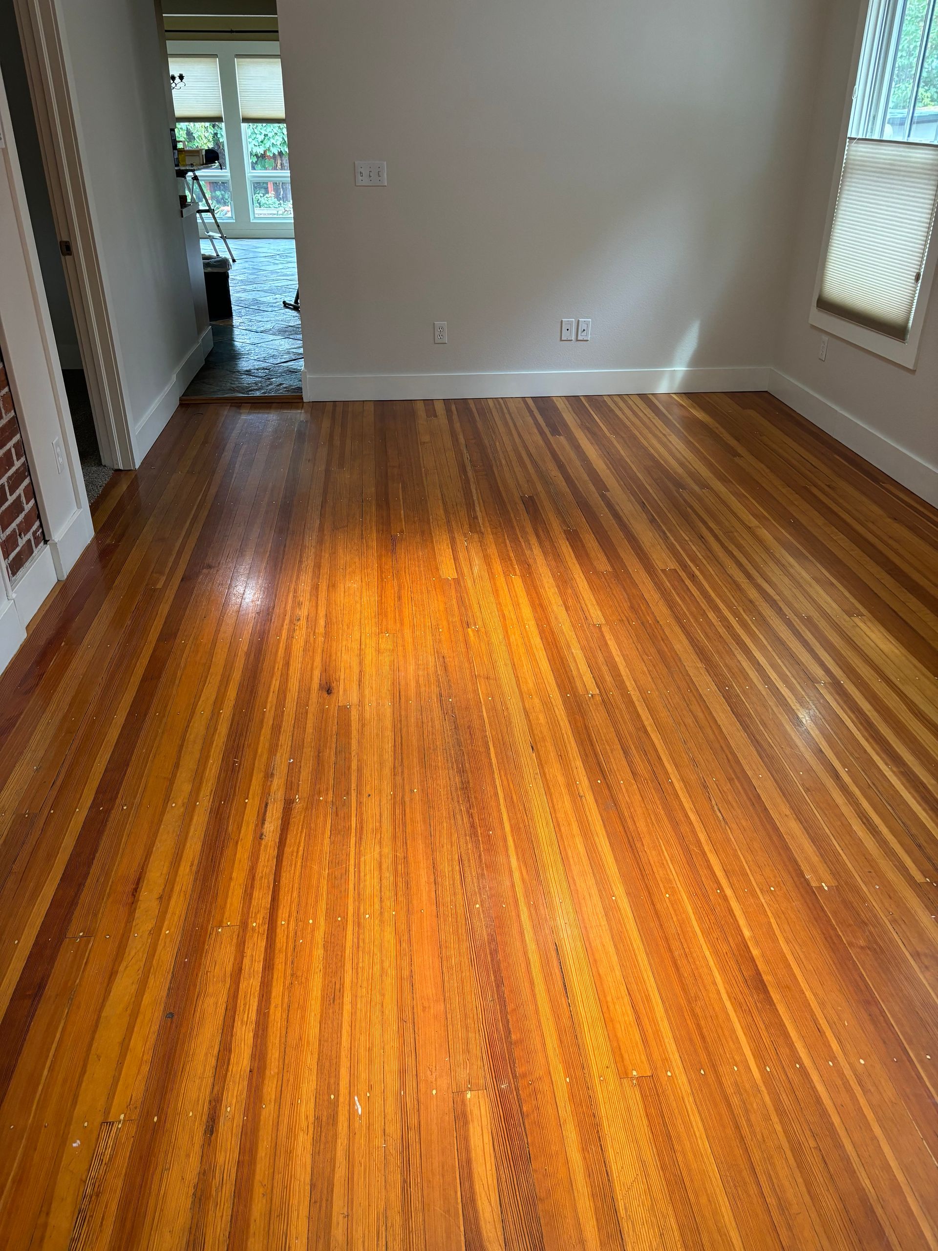 A living room with a wooden floor and white walls.