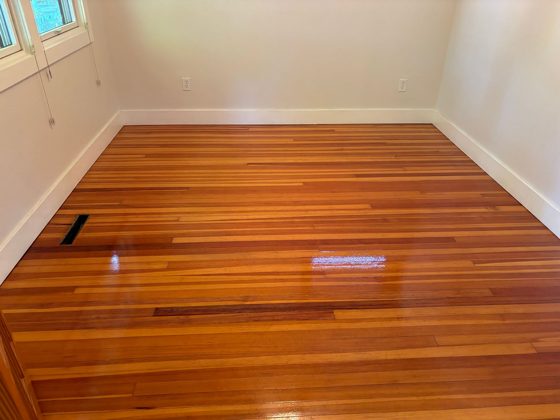 A room with a wooden floor and white walls