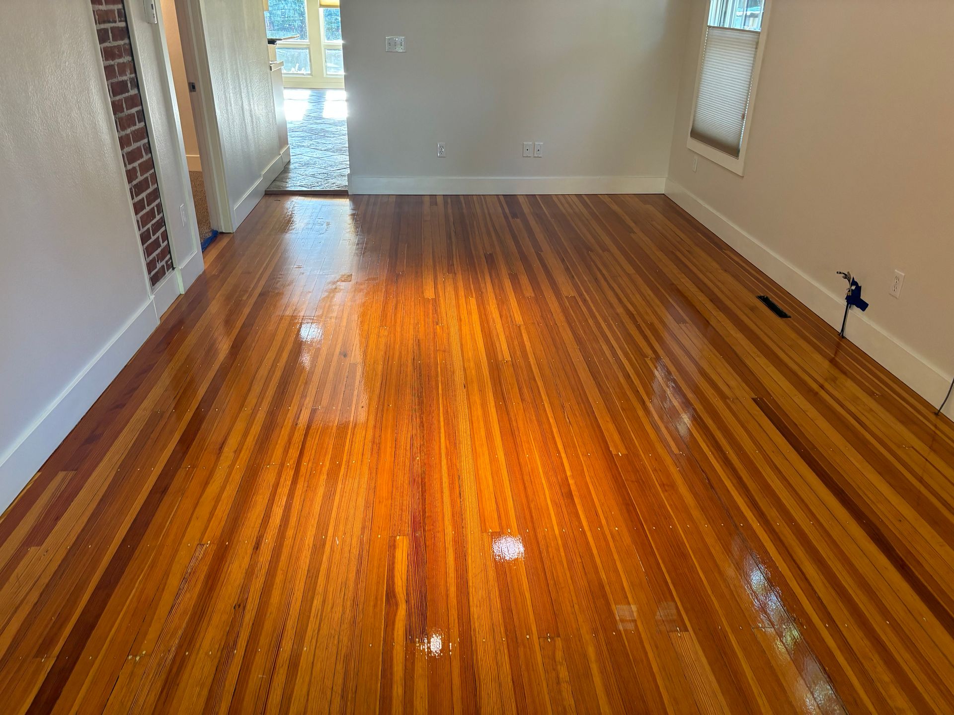 A living room with a wooden floor and white walls.