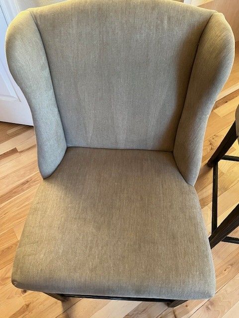 A chair is sitting on a wooden floor next to a wooden table.