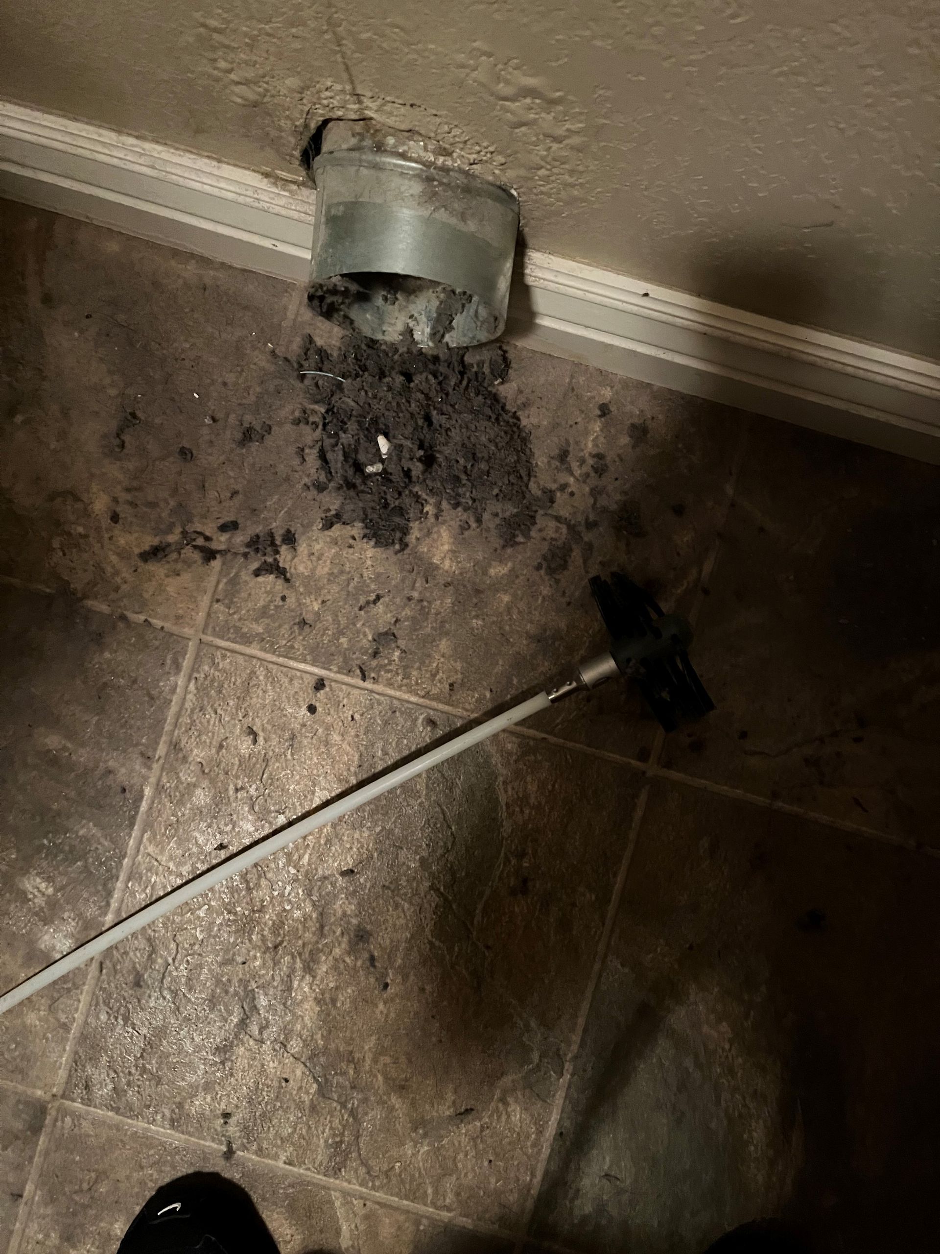 A person is cleaning the floor with a vacuum cleaner.