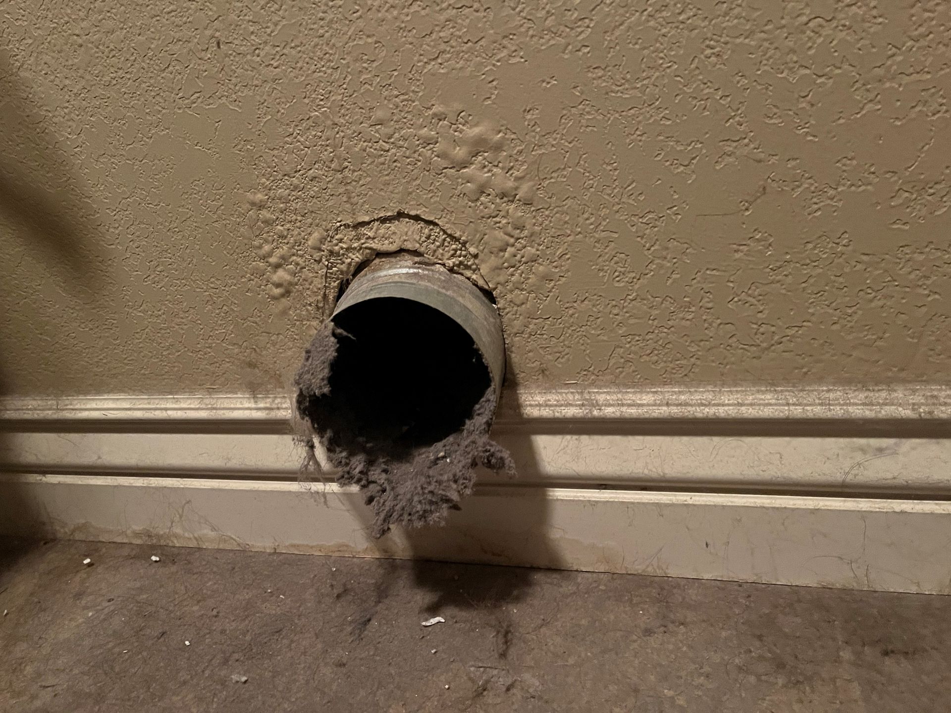 A hole in a wall with a pipe sticking out of it.
