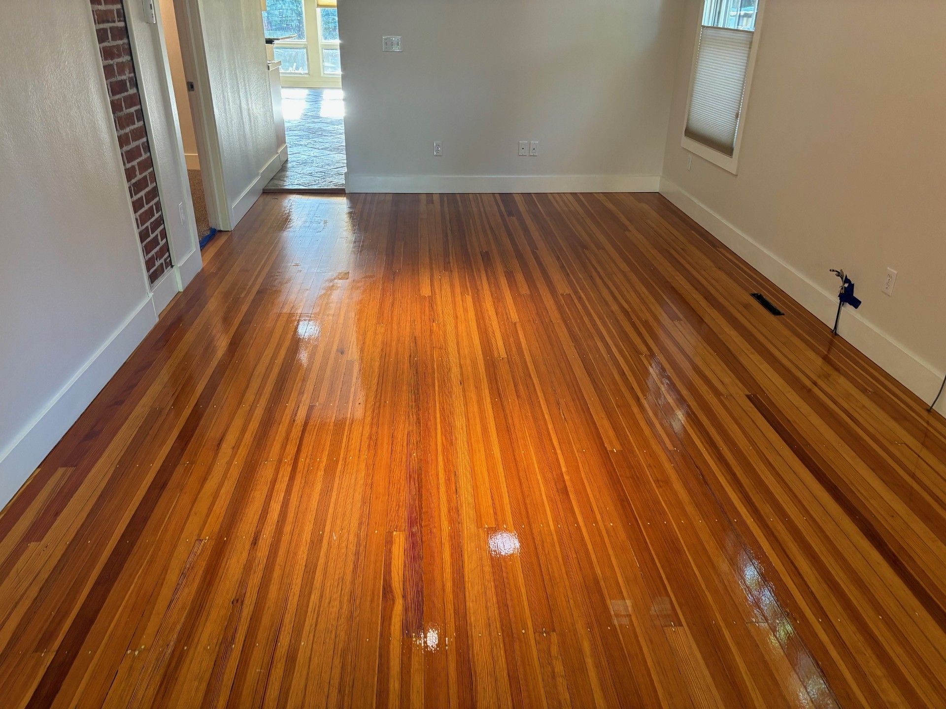 A living room with a wooden floor and white walls.