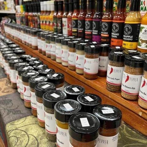 Shelves of assorted bottled sauces and jars lined up in a grocery store aisle