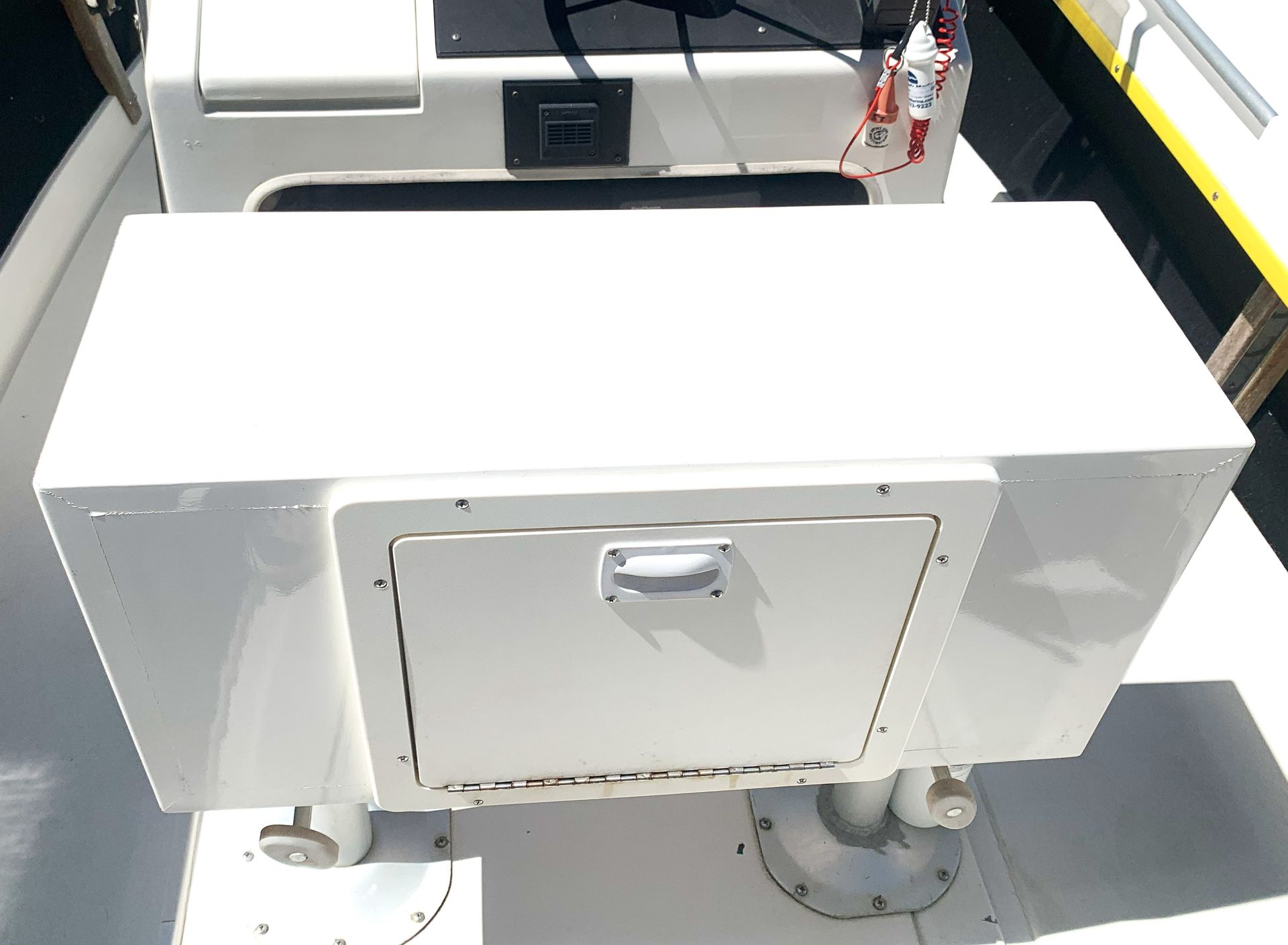 White storage box with a front hatch mounted on a boat deck