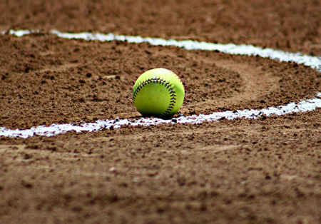 Yellow tennis ball on a clay court inside a white chalk line