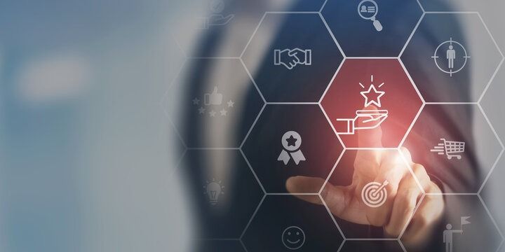 A hand touching a glowing star icon on a digital honeycomb interface, representing quality and business success.