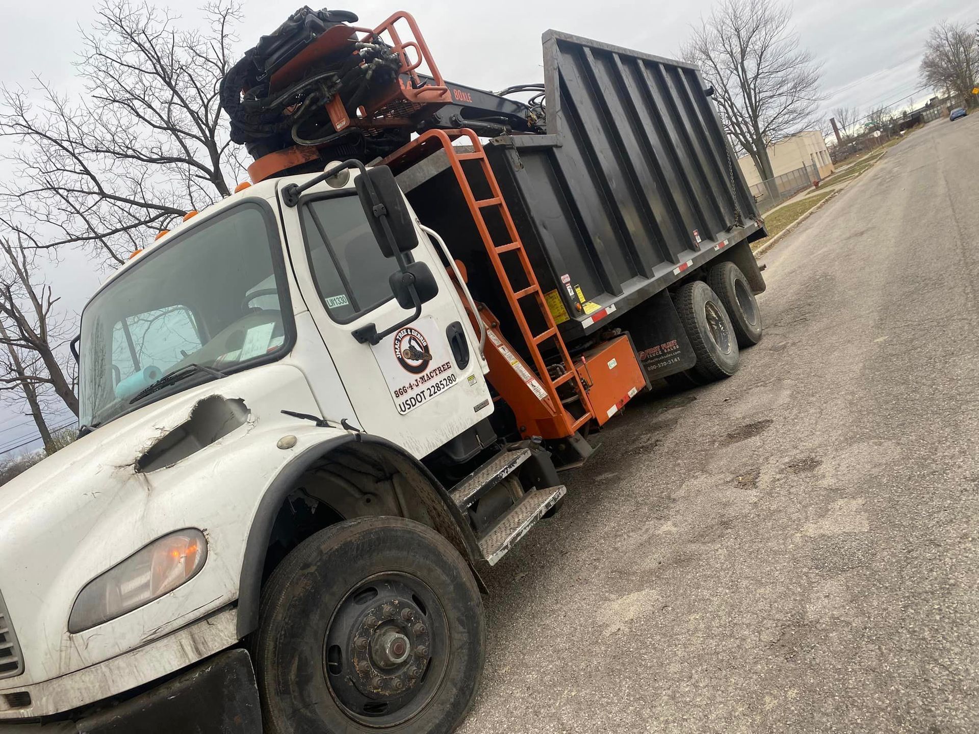 A dump truck is parked on the side of the road.