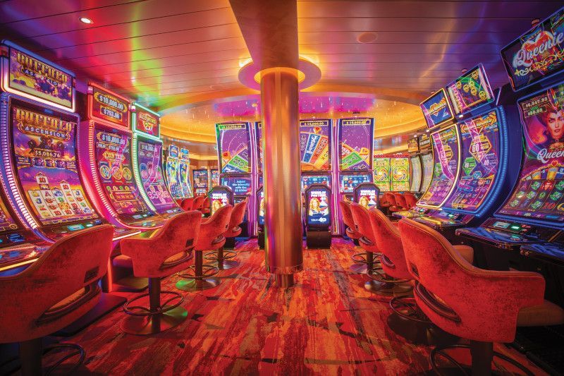 Casino with vibrant neon lights, slot machines, and red velvet chairs.