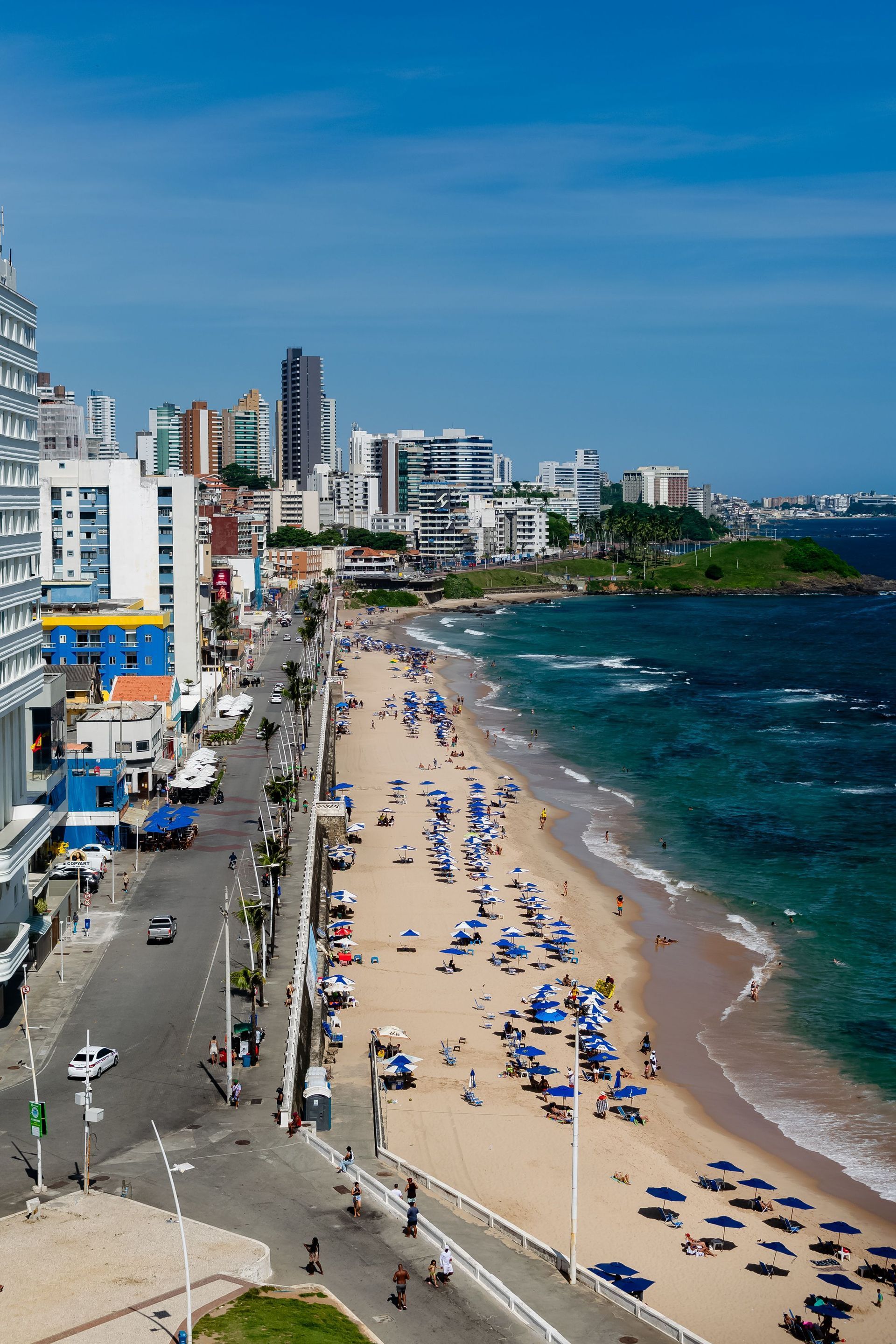 Condado Beach viewed from a rooftop with umbrella and sunbathers lining the beach