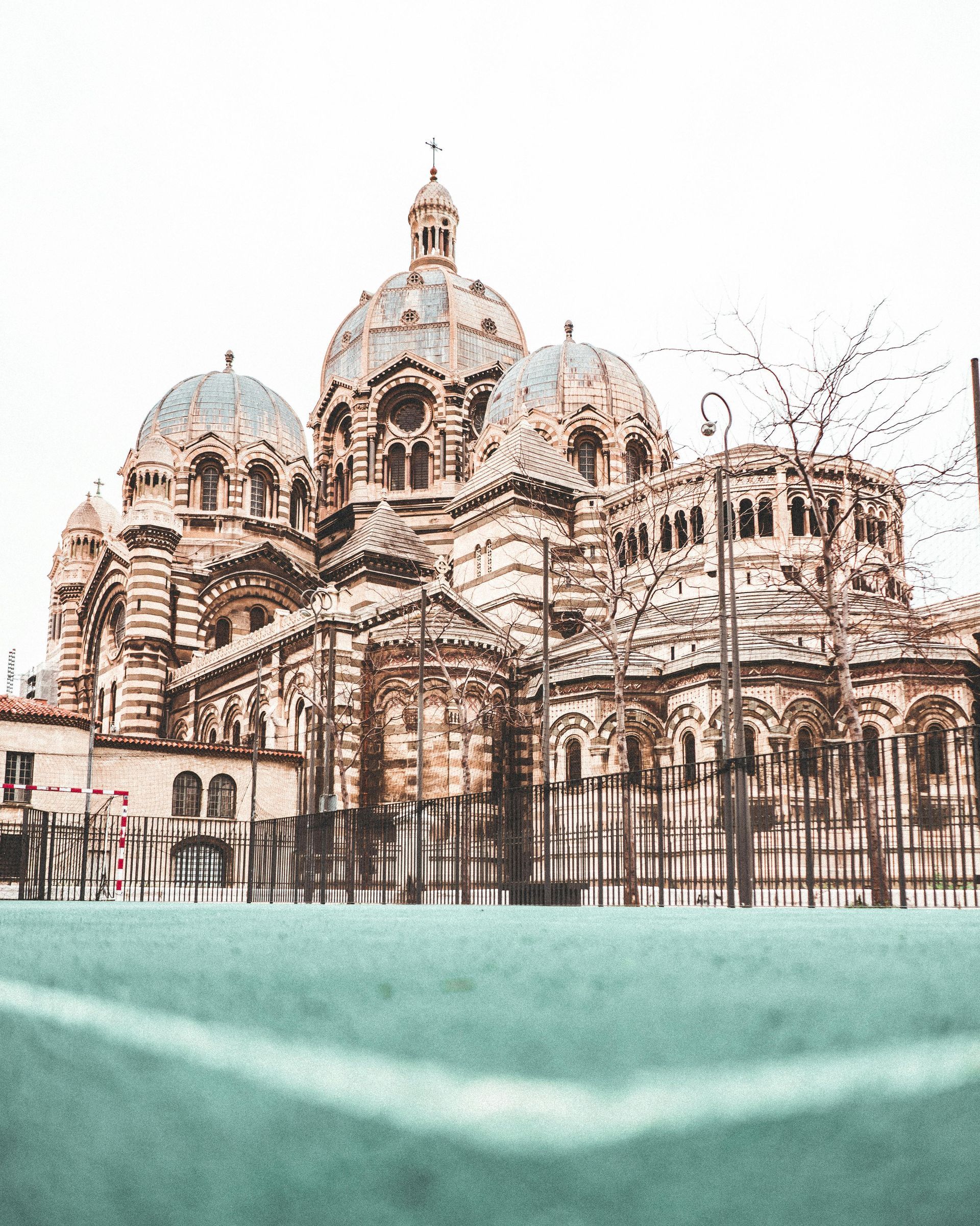 Basilica Notre-Dame de la Garde, Marseille, France, with ornate domes and pale stone facade against a cloudy sky.