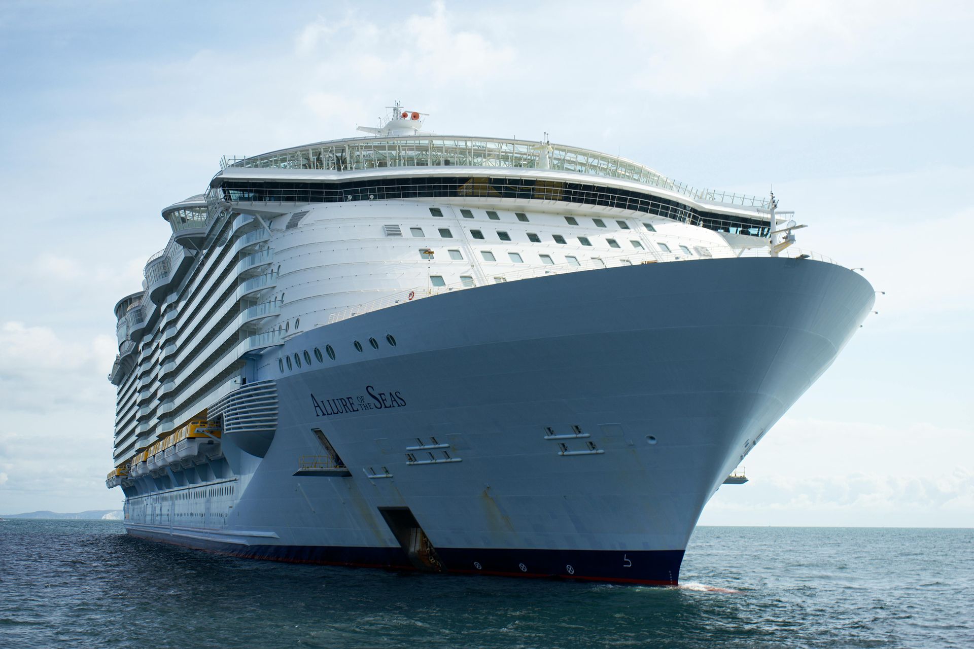 Large white cruise ship sailing on calm water under a clear sky