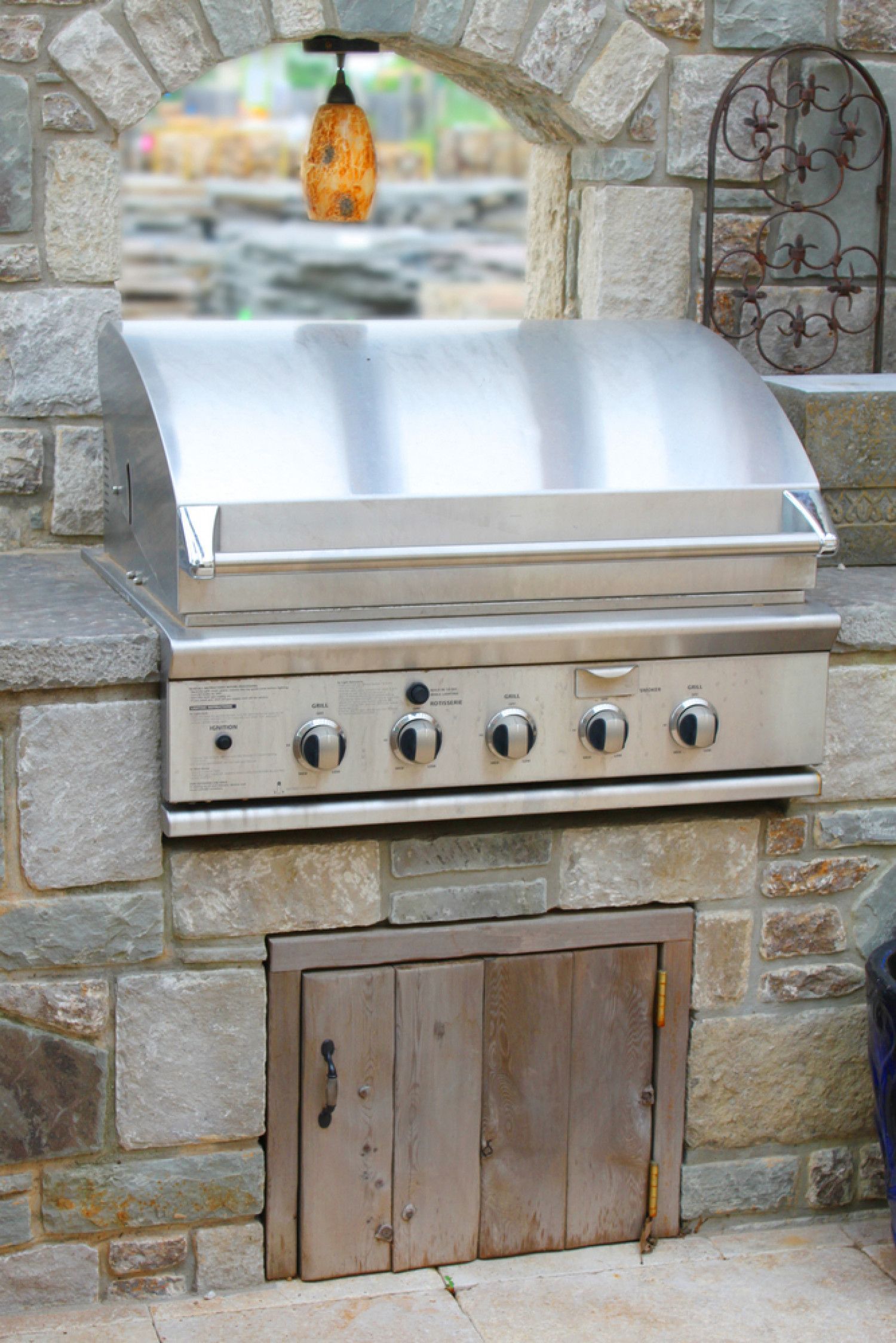 a stainless steel grill is built into a stone wall