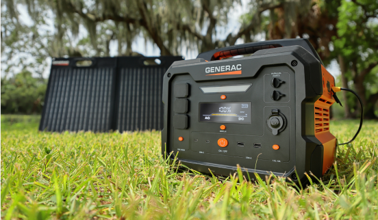 A generator is sitting in the grass next to a solar panel.