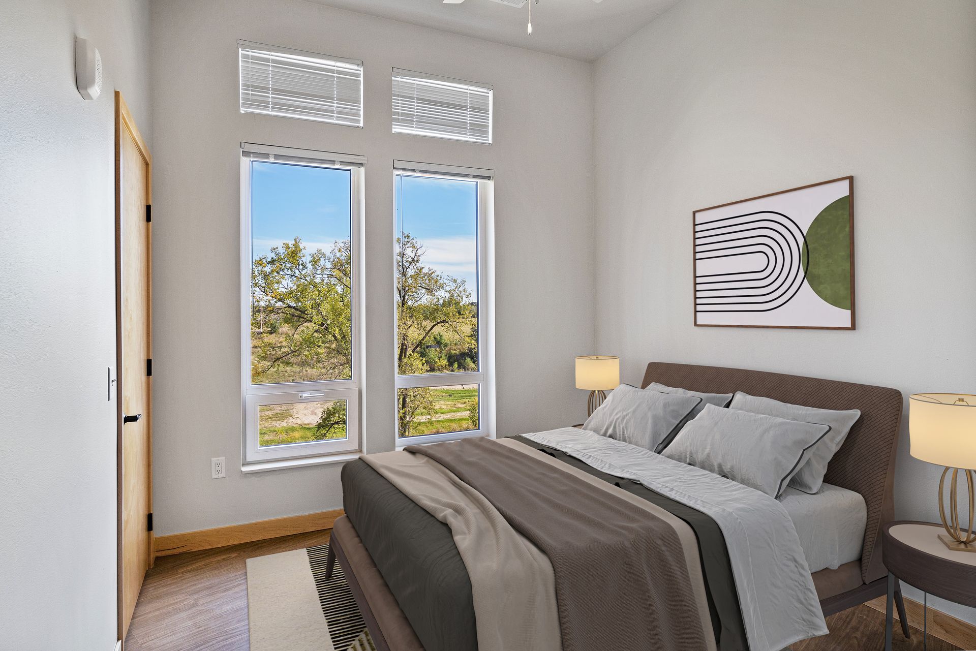 A bedroom with a bed , two windows and a painting on the wall.