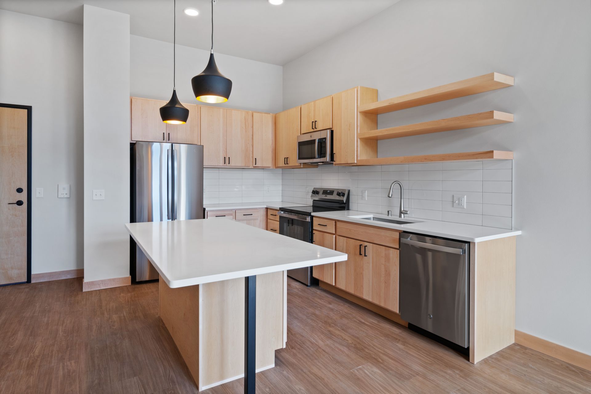 A kitchen with wooden cabinets , stainless steel appliances , and a large island.