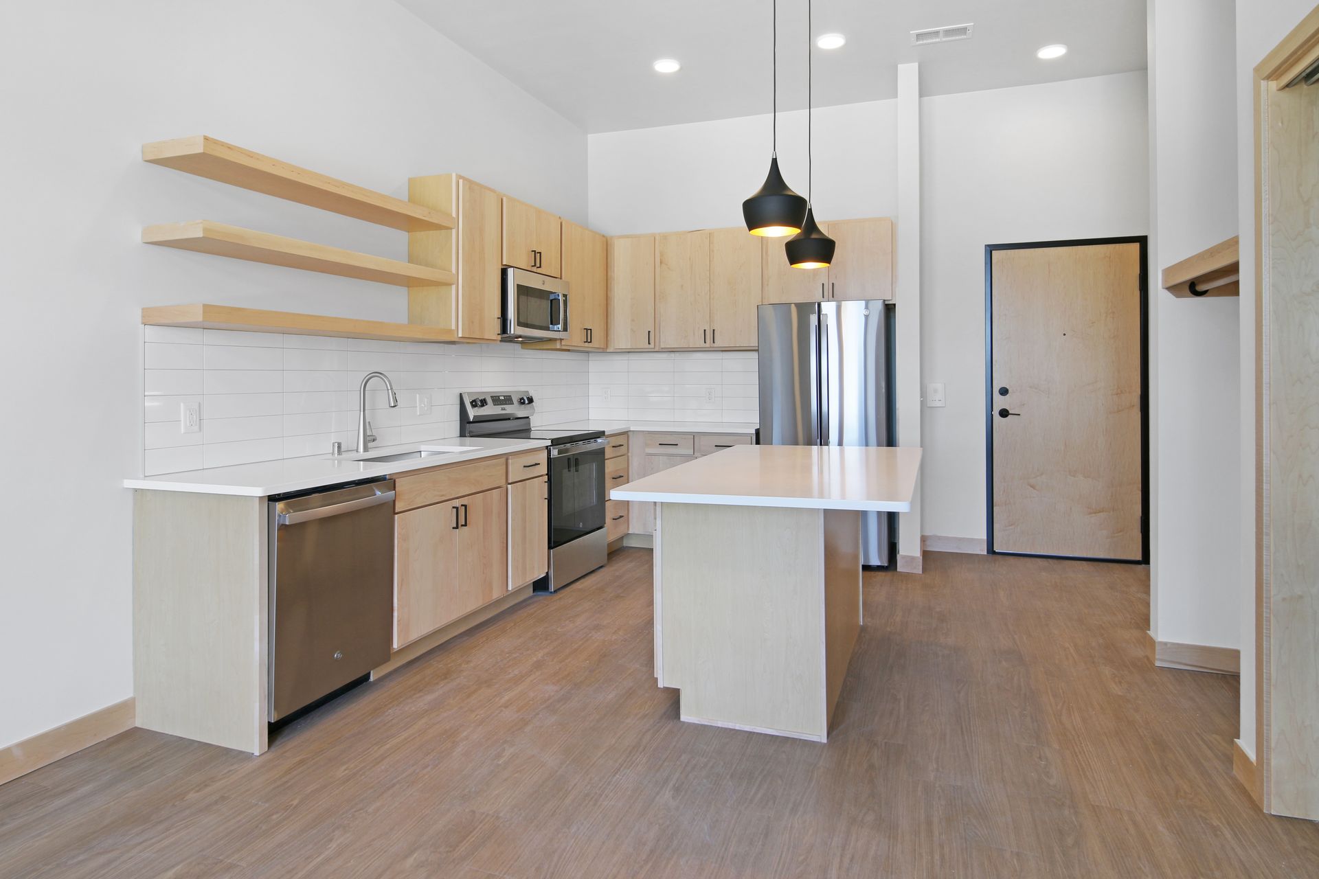 A kitchen with stainless steel appliances and wooden cabinets.