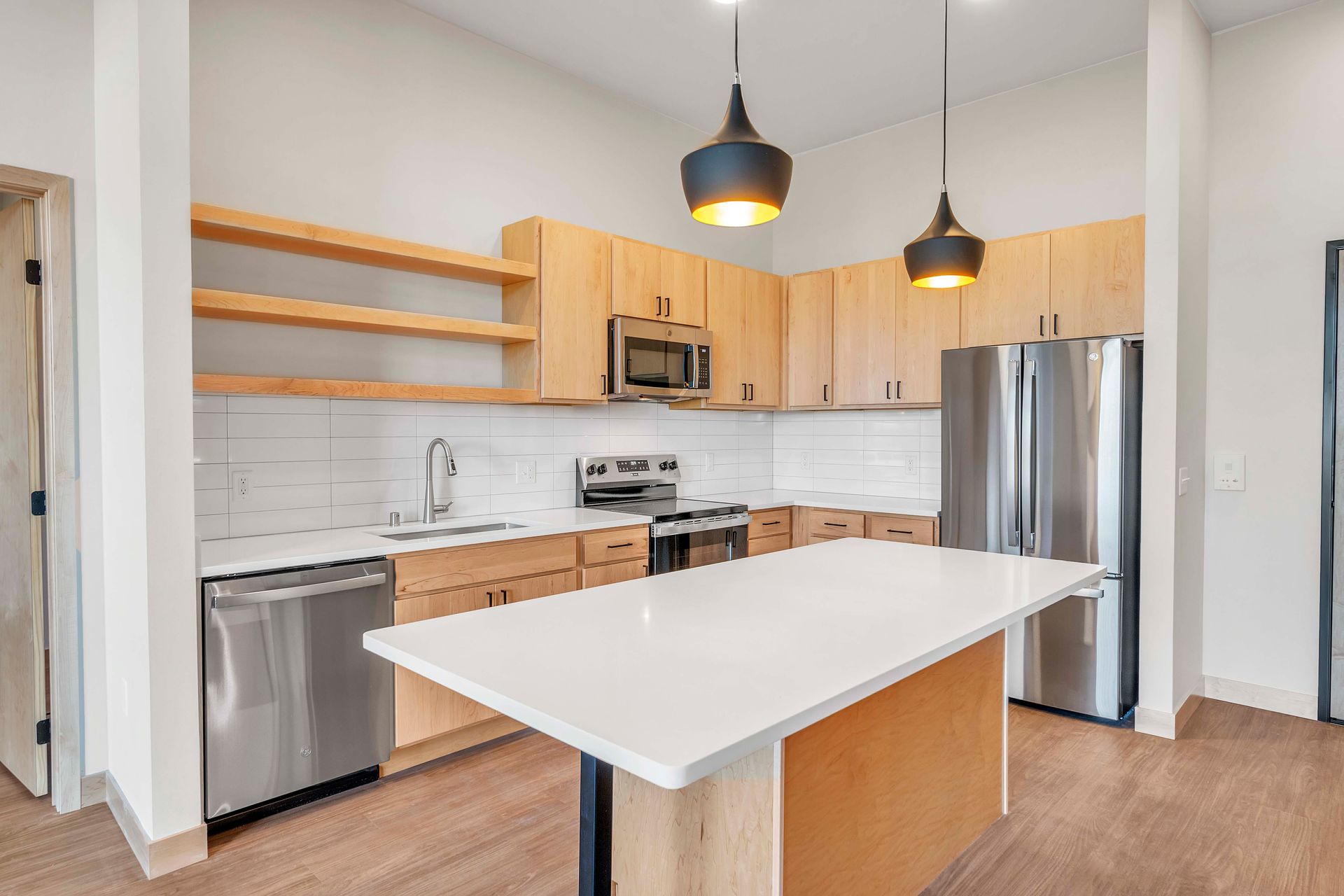 A kitchen with stainless steel appliances , wooden cabinets , and a large island.