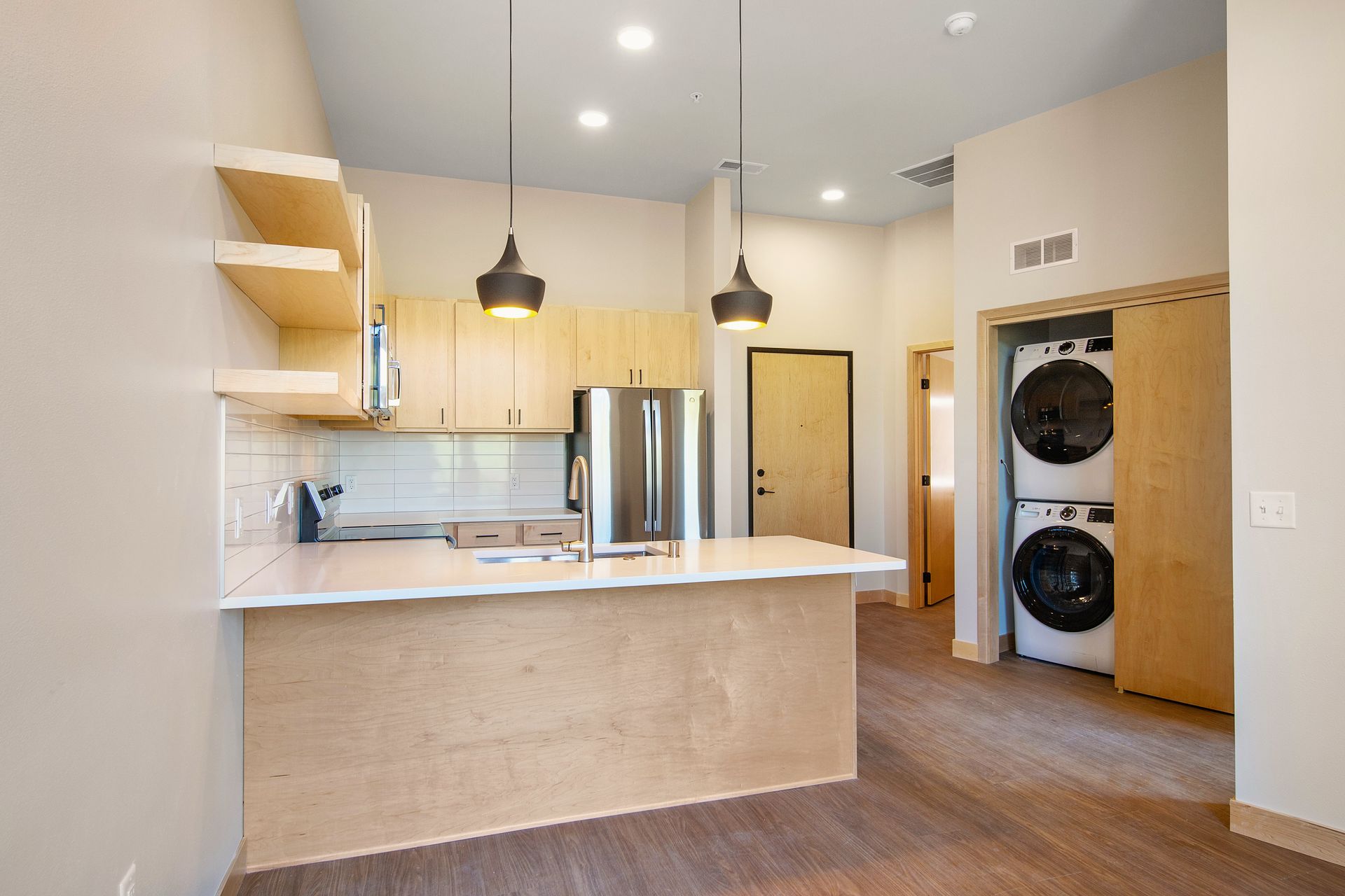 A kitchen with a washer and dryer stacked on top of each other.