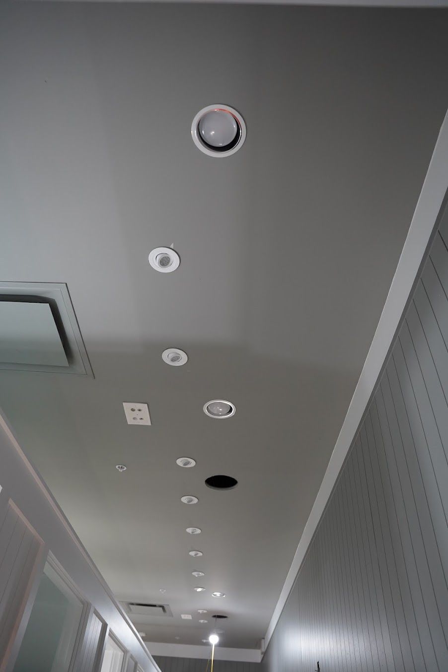 A bathroom under construction with a walk in shower and a door leading to another room.