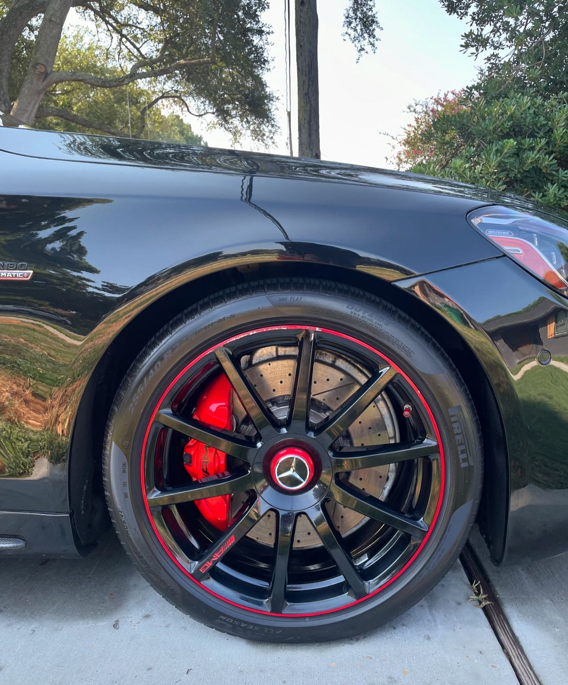 A black car with red rims and brake calipers