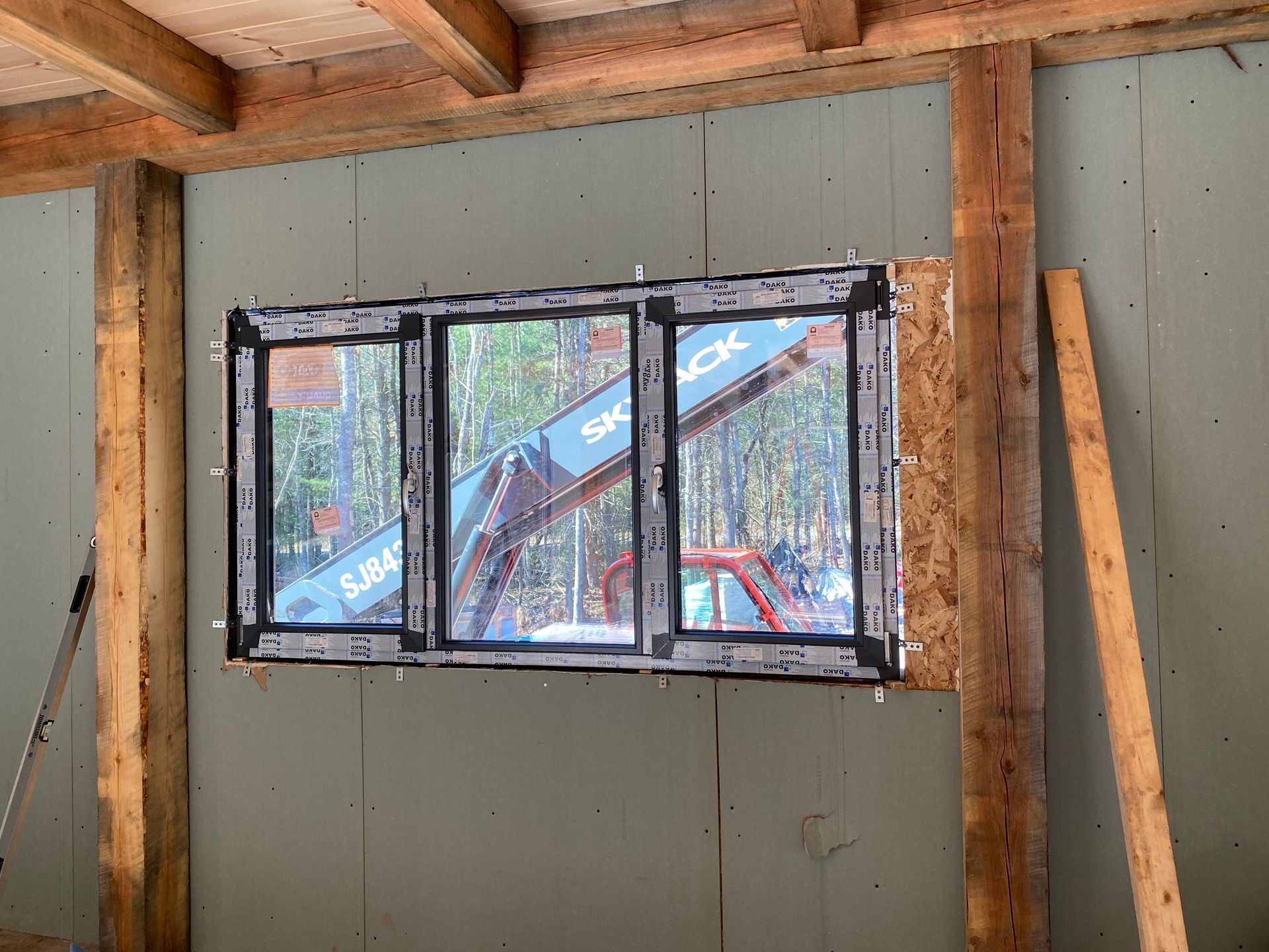 A window is being installed in a wooden building.