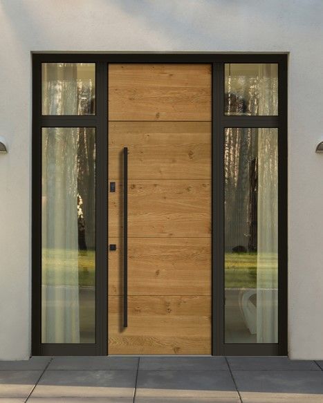 A wooden door with a black handle is on a white building