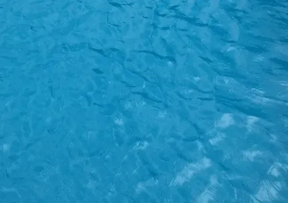 A close up of a blue water surface in a swimming pool.