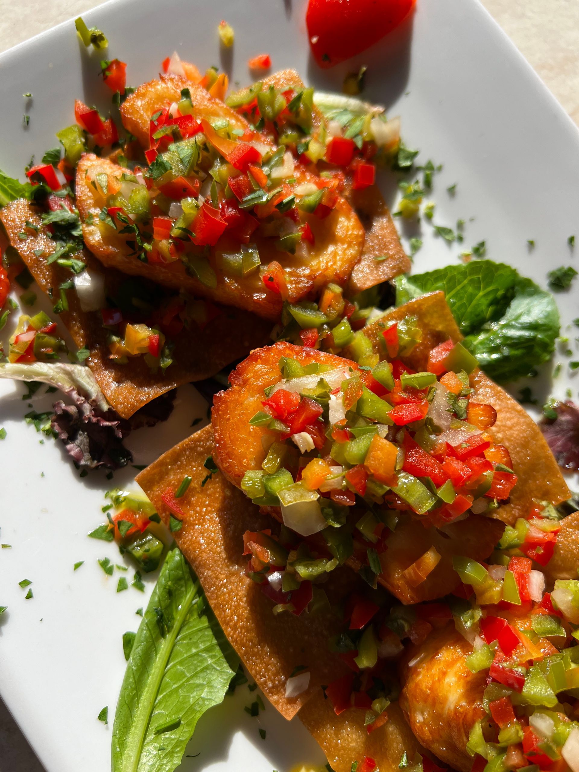 Bruschetta with diced tomatoes and herbs on toasted bread, garnished with basil on a white plate