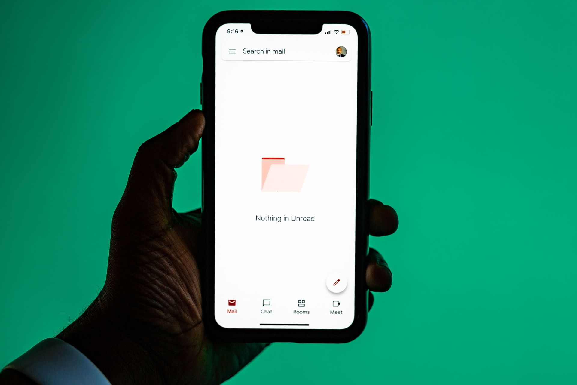 Hand holding a smartphone with a white app screen against a green background.