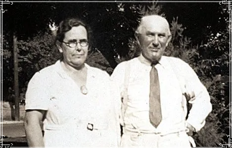 Two people standing outdoors, wearing light-colored shirts, in a black-and-white photo.