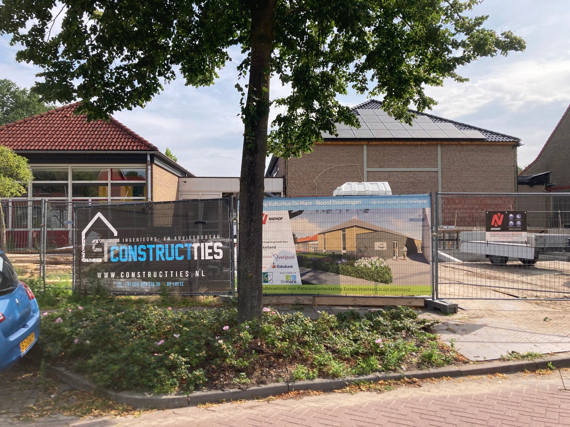 Bouwplaats met een tijdelijk hekwerk waaraan spandoeken met de tekst 