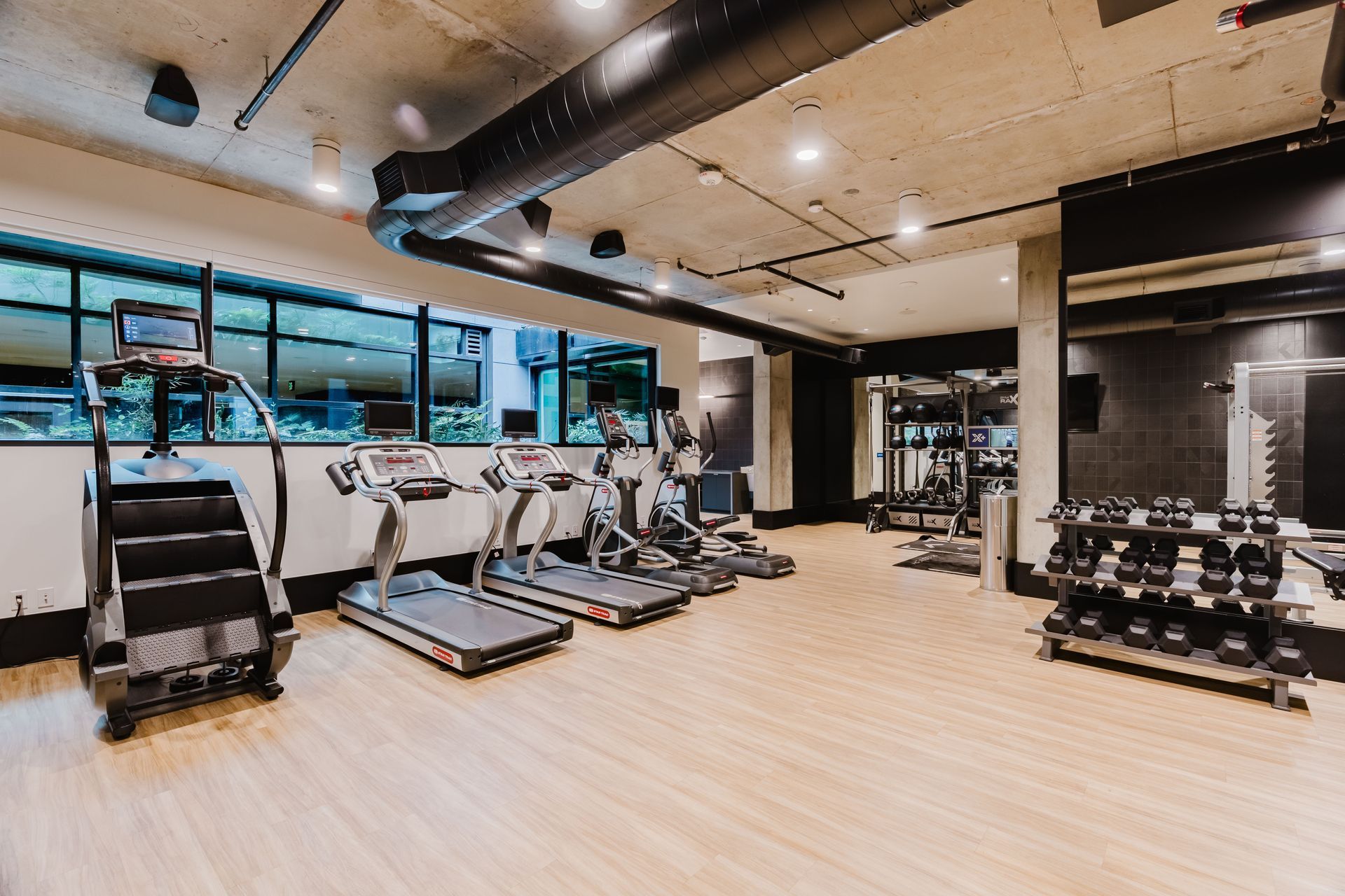 There are many treadmills and dumbbells in the gym.