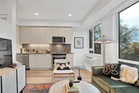 A living room with a couch , chair , table , and television.