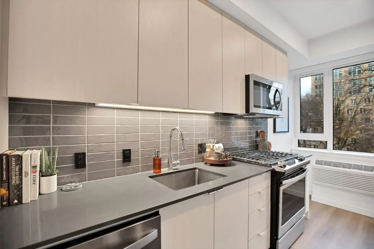 A kitchen with a sink , stove , microwave and dishwasher.