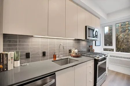 A kitchen with a sink , stove , microwave and dishwasher.