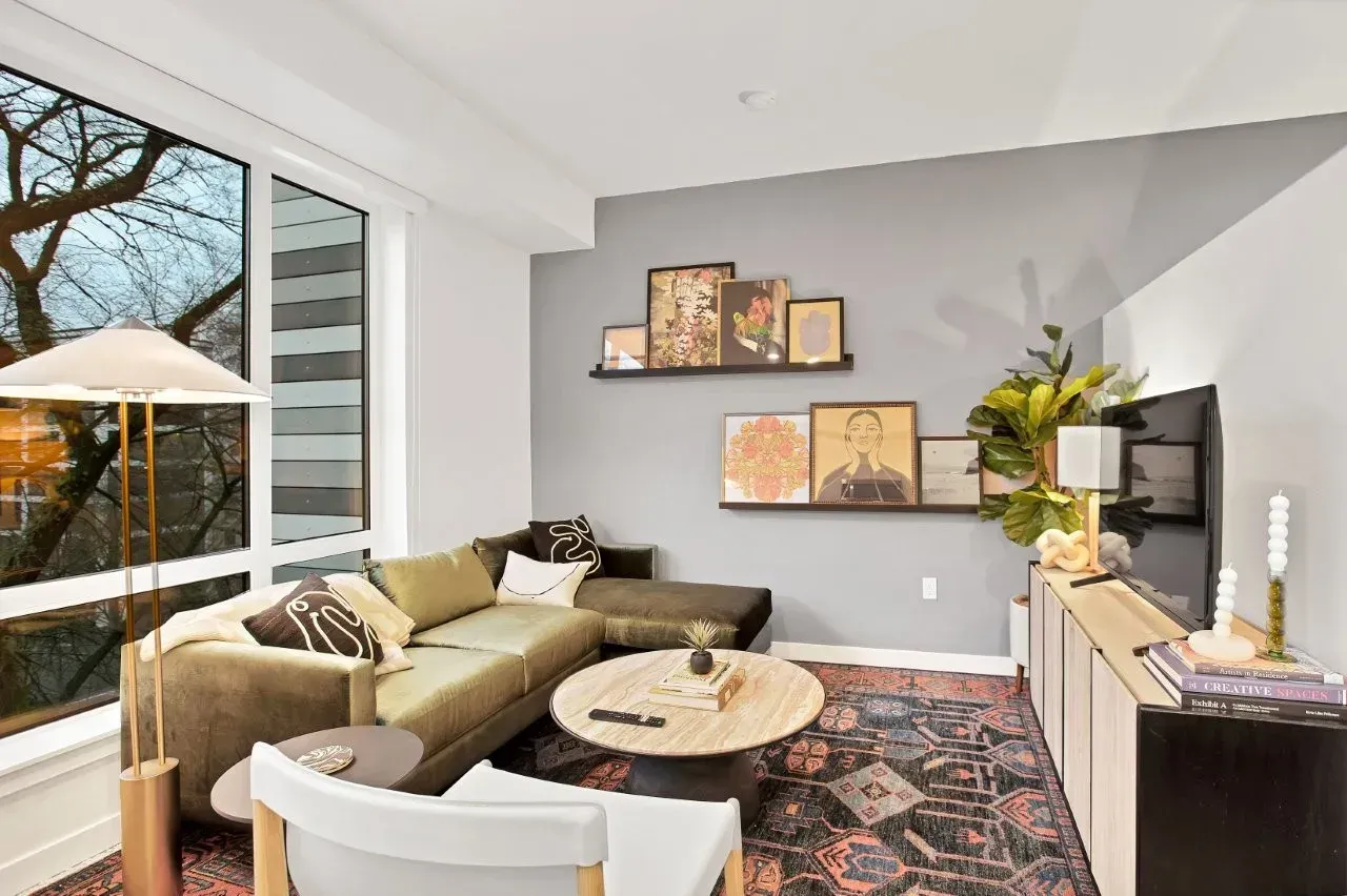 A living room with a couch , chair , coffee table , and television.