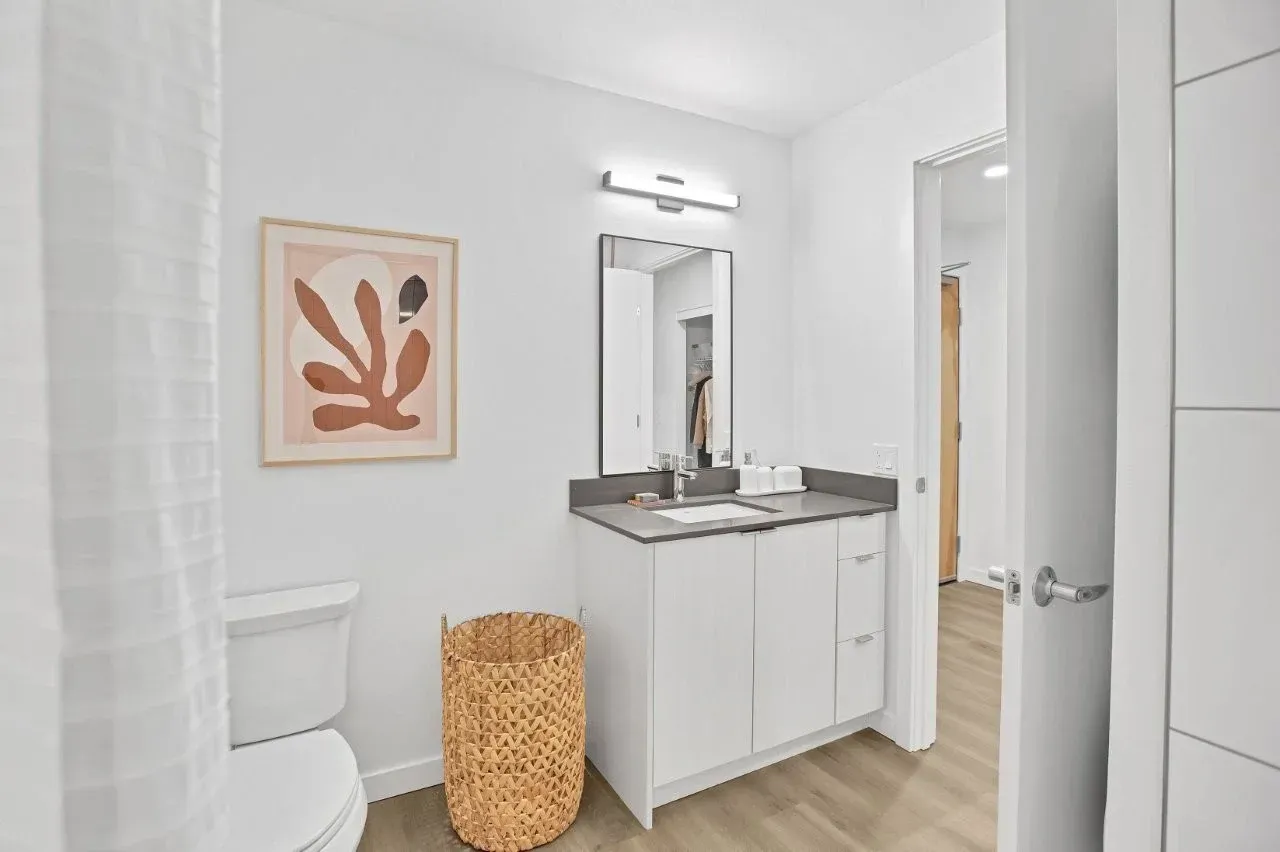 A bathroom with a toilet , sink , and mirror.