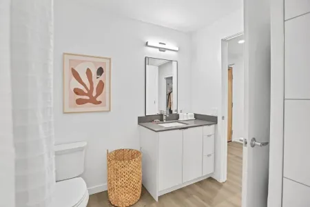 A bathroom with a toilet , sink , and mirror.