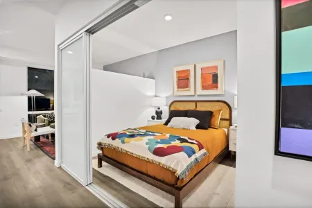 A bedroom with a bed and a painting on the wall.