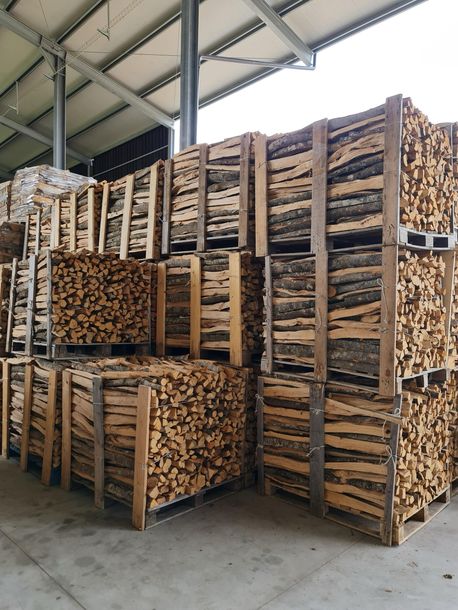 Un magazzino pieno di pallet di legno accatastati uno sopra l'altro.