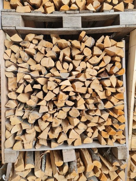 Una catasta di legna è accatastata sopra un pallet di legno.