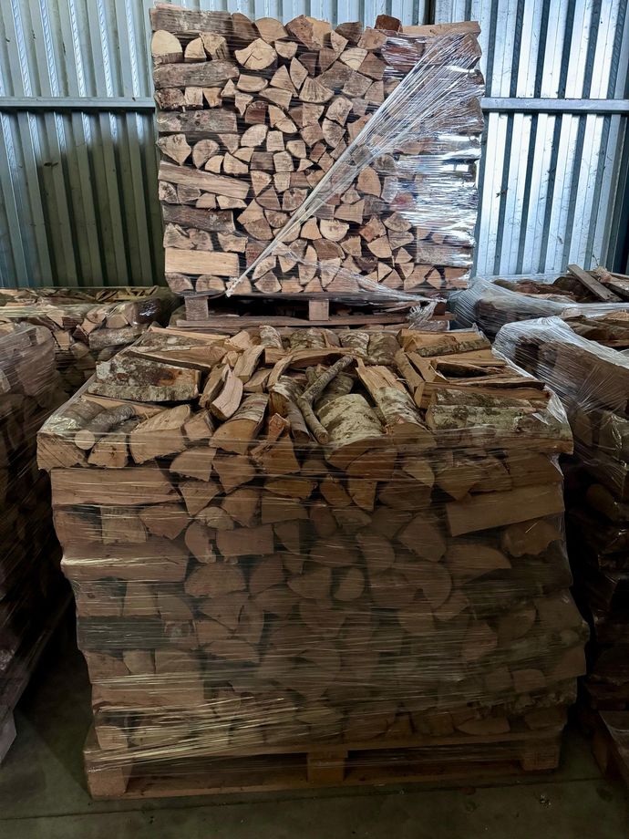 Una catasta di legna è posta sopra un pallet in un magazzino.