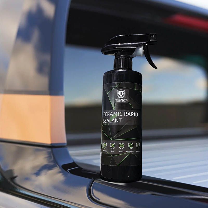 Black spray bottle labeled “Ceramic Rapid Sealant” on a car surface near a window