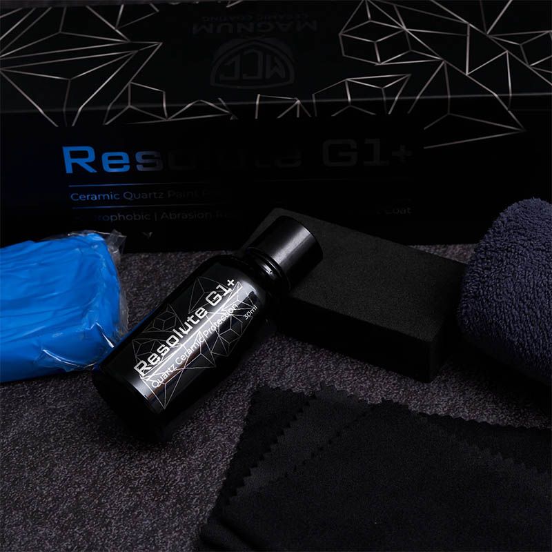 Black Reuss G1 bottle, blue pouch, and black case on a dark textured surface with branded box behind