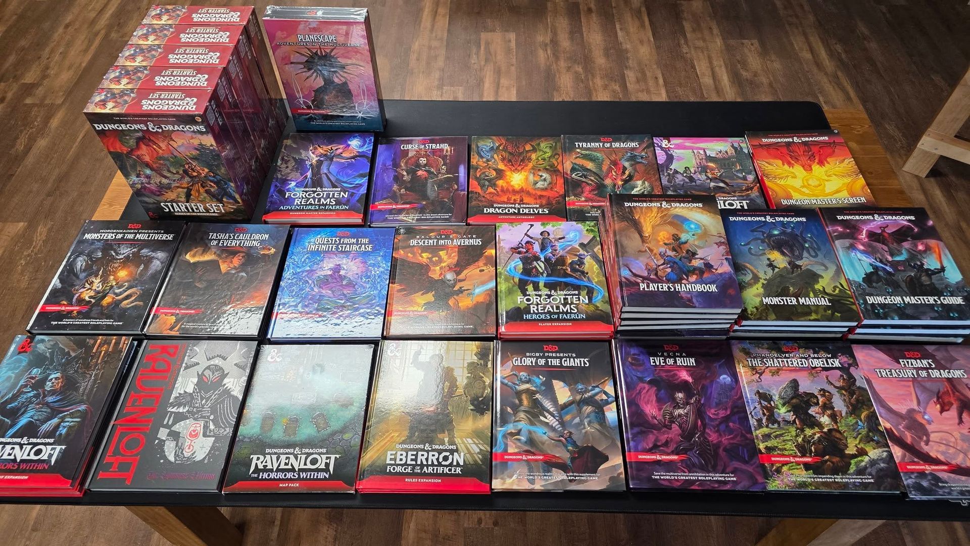 Assorted colorful trading card game booster boxes and decks arranged on a wooden floor.