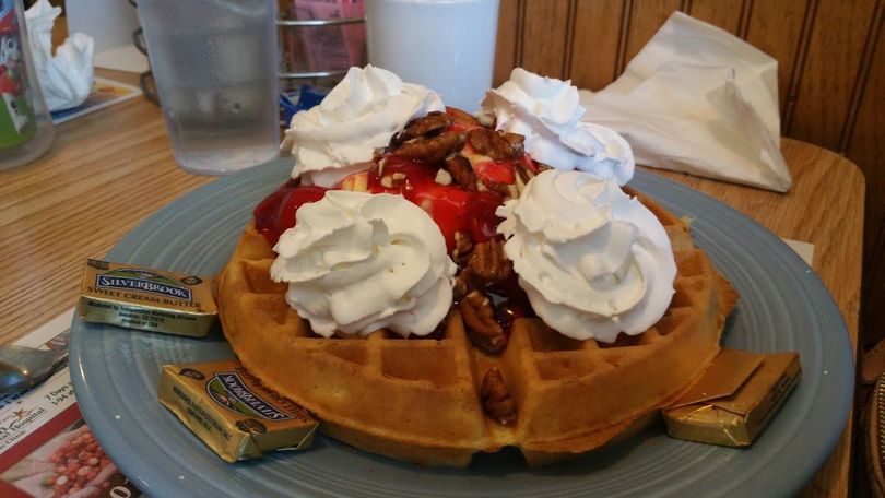 Classic American diner breakfast plate with eggs, pancakes, bacon, and coffee
