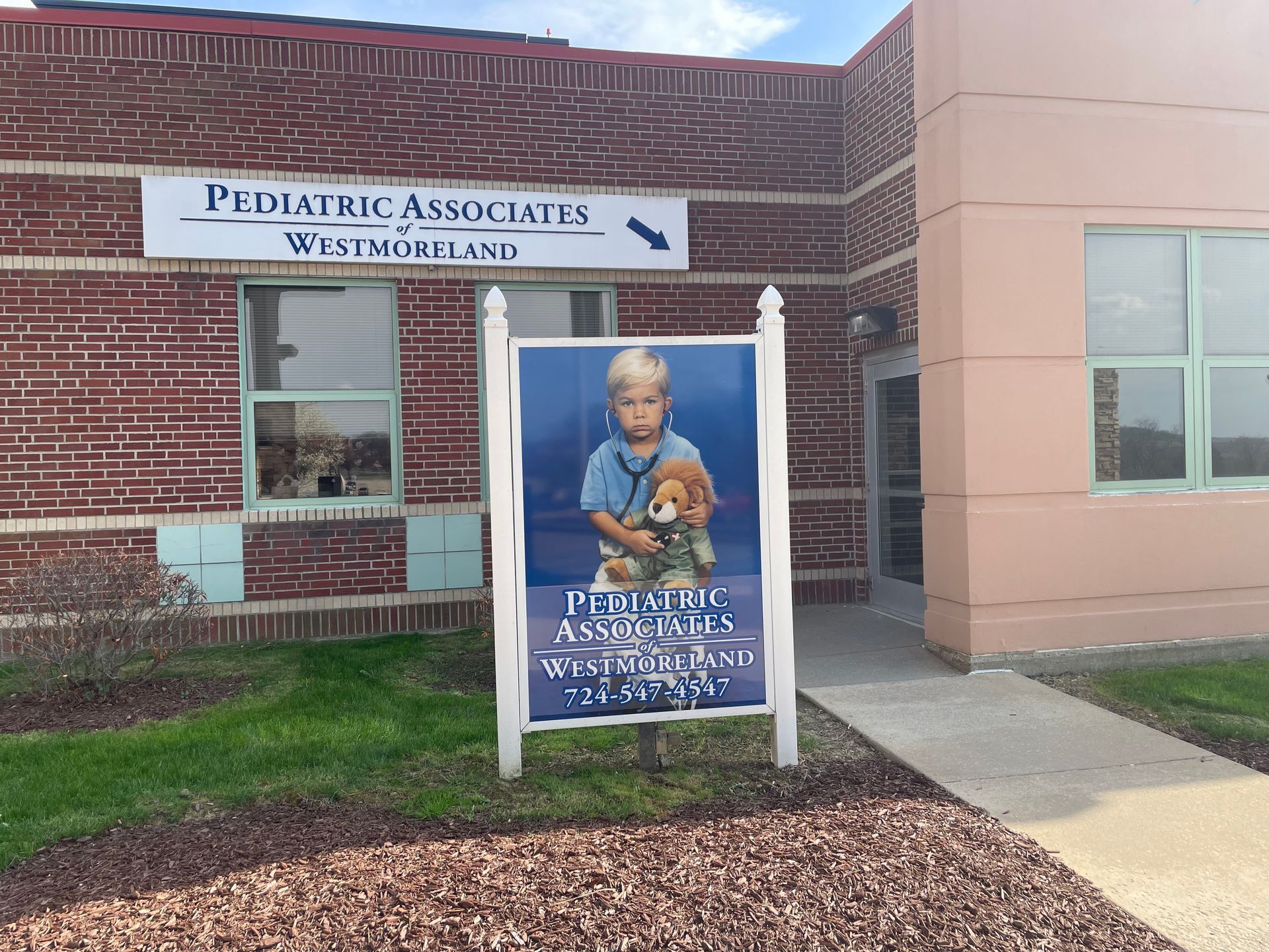 A Pediatric Associates of Westmoreland building with a sign in front of it.