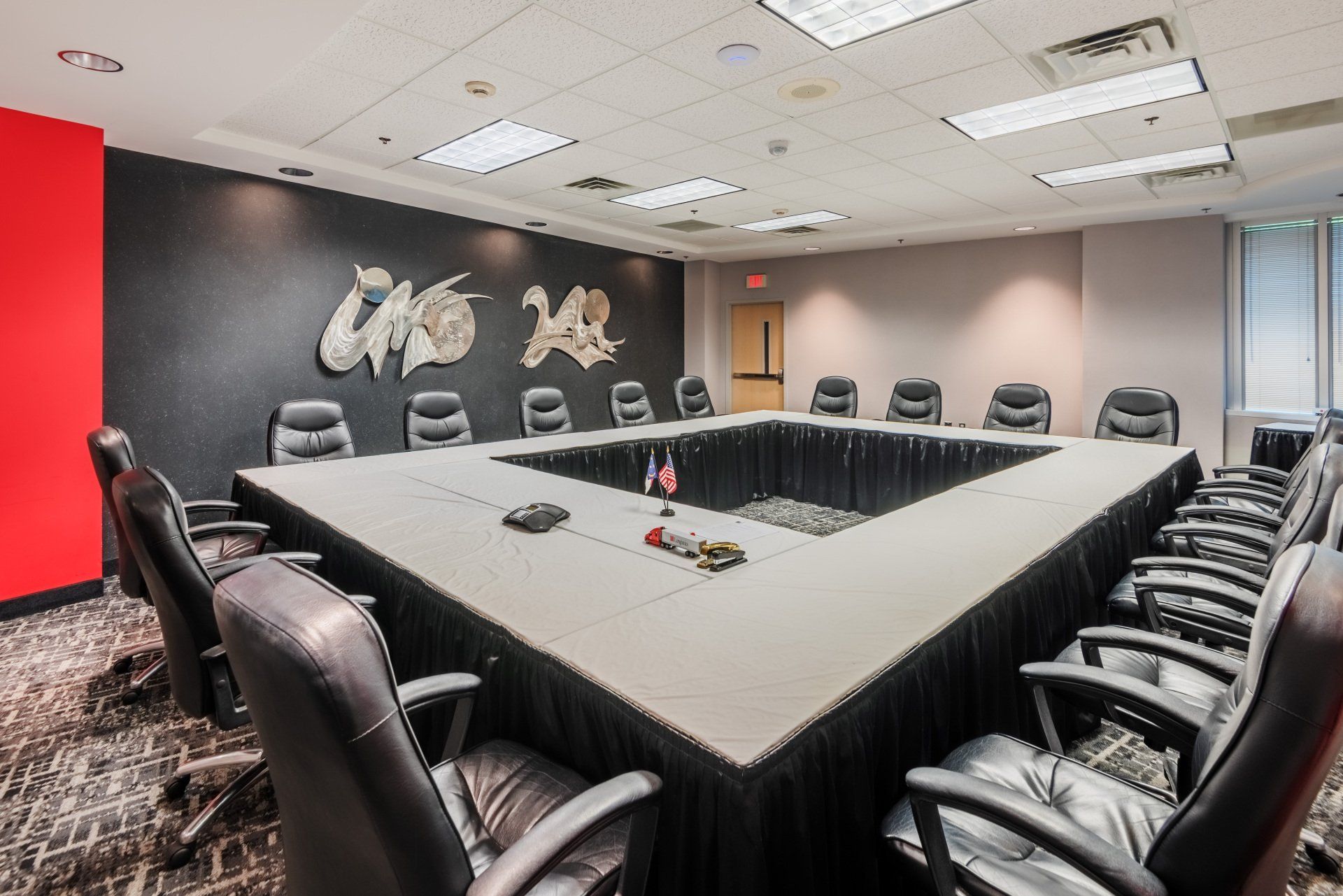 A conference room with a large table and chairs